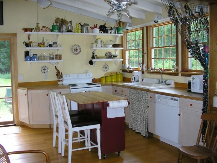 Μικρή κουζίνα σετ μικρό τραπεζάκι κουζίνας ανοιχτό κίτρινο χρώμα τοίχου ανοιχτά ράφια