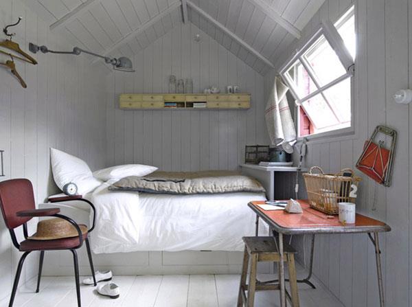 μικρό υπνοδωμάτιο ψηλό κρεβάτι ασυνήθιστη λάμπα τοίχου