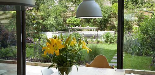 μικρό αστικό κήπο ξύλινο δάπεδο λουλούδια κίτρινη τραπεζαρία