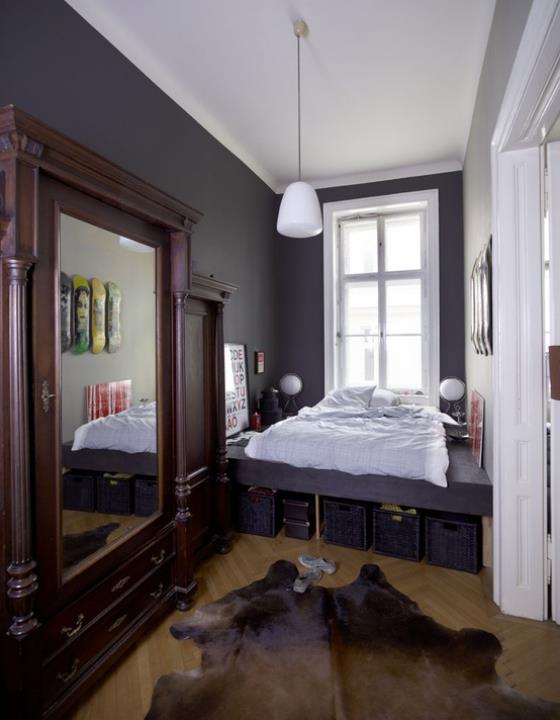 το μικρό κρεβατοκάμαρα μωβ κυριαρχεί στο μεγάλο κρεβάτι καθρέφτη τοίχου που ταιριάζει με καλάθια κάτω από το κρεβάτι για να αποθηκεύσει τα πράγματα