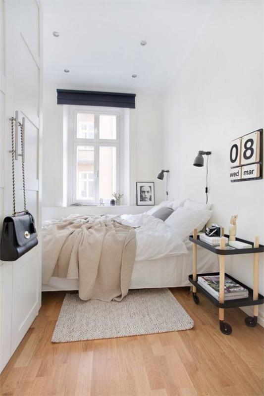 μικρό υπνοδωμάτιο απλό σκανδιναβικό σχέδιο λευκό κυρίαρχο τραπέζι στο ημερολόγιο τροχών στον τοίχο