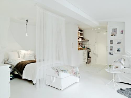 μικρό διαμέρισμα δείχνει το μέγεθος των διαφανών λευκών κουρτινών στο κρεβάτι