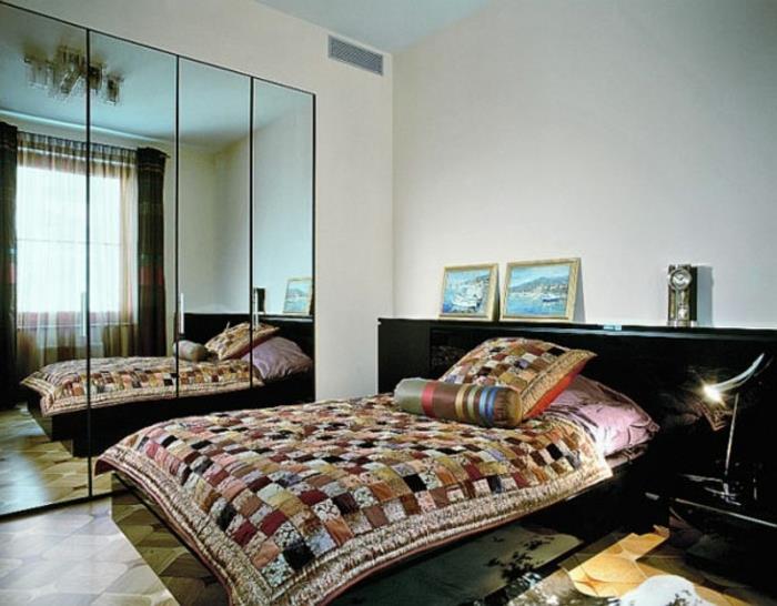 μικρό υπνοδωμάτιο με διπλό κρεβάτι πάπλωμα στρωματοειδές μοτίβο καθρέφτη τοίχου