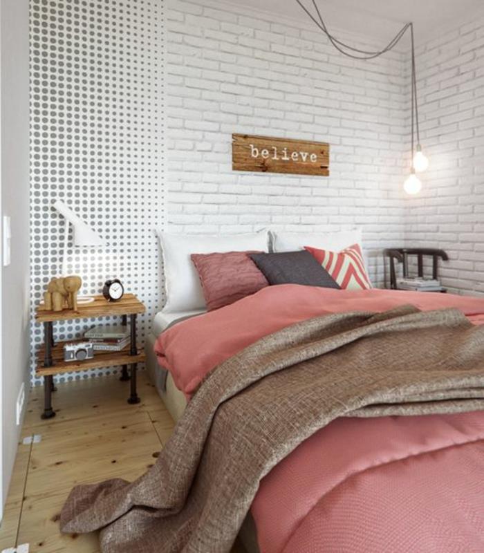 Μικρό υπνοδωμάτιο με διπλό κρεβάτι, ροζ κλινοσκεπάσματα από λευκό τούβλο, λαμπτήρες τοίχου, κρεμαστά φώτα