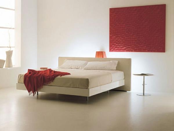 άνετο κρεβάτι με κομψή διακόσμηση τοίχου και κουβέρτα από κόκκινο μαλλί