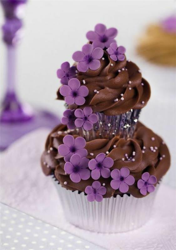 κέικ το ένα πάνω στο άλλο με μοβ λουλούδια σοκολάτας