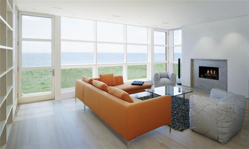 μινιμαλιστικό πορτοκαλί δερμάτινο καναπέ γυάλινο τραπέζι με θέα στη θάλασσα