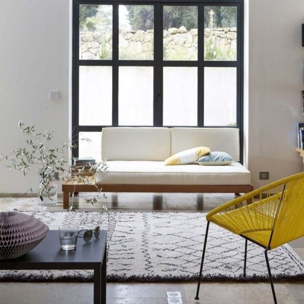 μοντέρνο σαλόνι με πολύ φωτισμό ημέρας διθέσιο μπροστά από το παράθυρο λουλούδια γκρι χαλί