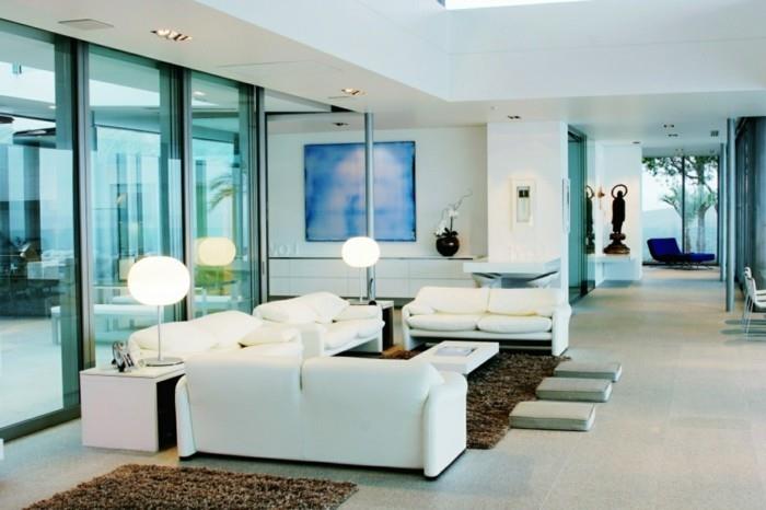 μοντέρνοι ζωντανοί λευκοί καναπέδες στο σαλόνι και καφέ χαλιά