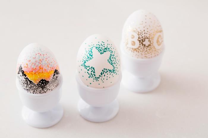 Πασχαλινά αυγά ζωγραφίζοντας γράμματα αστέρια που διακοσμούν λευκά αυγά