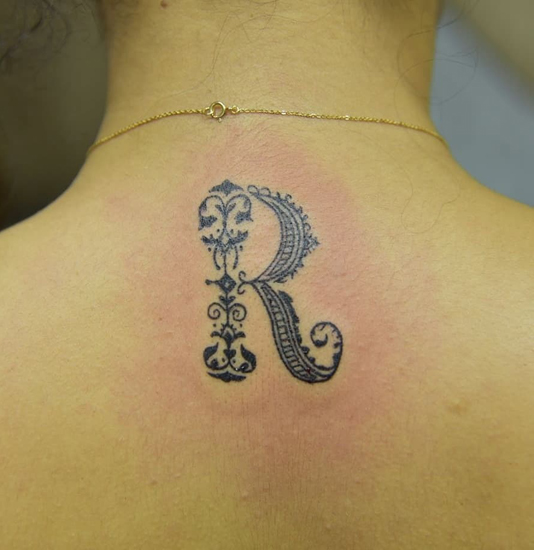 R raidės tatuiruotės dizainas ant kaklo