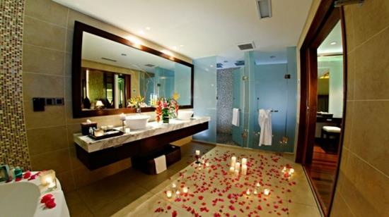 ρομαντικά κεριά μπάνιου και πέταλα λουλουδιών στο πάτωμα