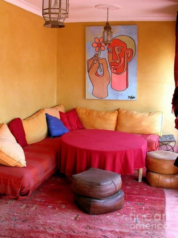 ροζ-κόκκινο κορεσμένα χρώματα χρυσοκίτρινοι τοίχοι καναπέδες μαξιλάρια δερμάτινα σκαμπό