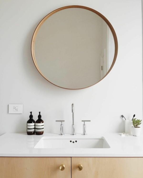 στρογγυλός καθρέφτης μπάνιου μοντέρνο μπάνιο λευκοί τοίχοι ανοιχτόχρωμο ξύλο