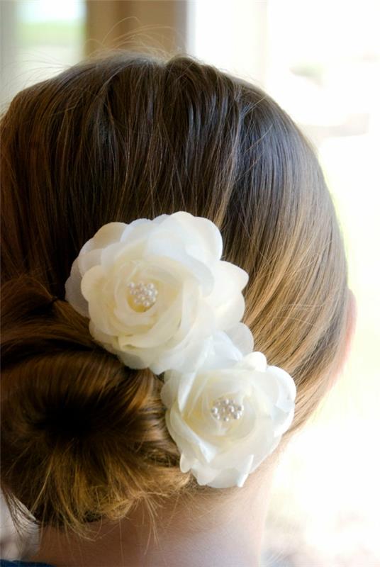 κομψά νυφικά χτενίσματα κουλούρι χτένισμα με λευκά τριαντάφυλλα