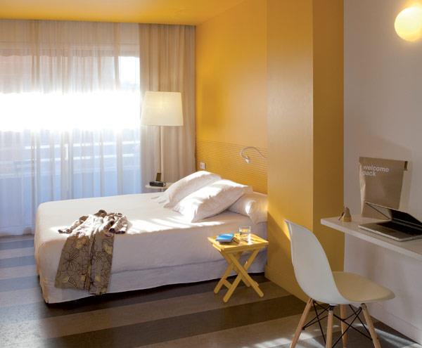 κομψό απλό ξενοδοχείο Ισπανία υπνοδωμάτιο κίτρινος τοίχος