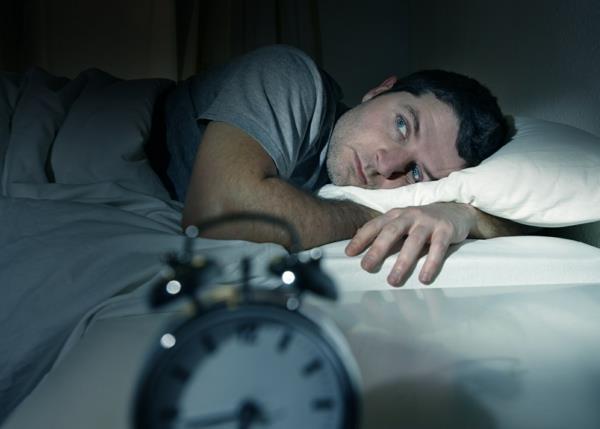 άντρας στο κρεβάτι με τα μάτια ανοιχτά που πάσχουν από αϋπνία διαταραχή ύπνου