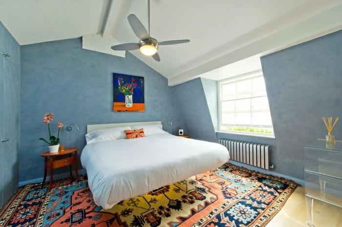 υπνοδωμάτιο με κεκλιμένη οροφή μπλε τοίχους και χρωματιστό χαλί