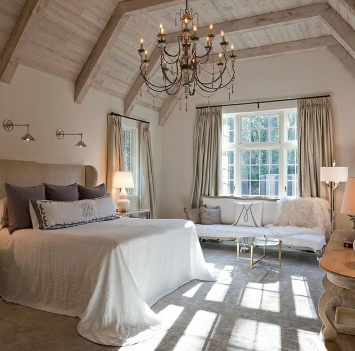 υπνοδωμάτιο με κλίση ξύλινα δοκάρια και όμορφος πολυέλαιος