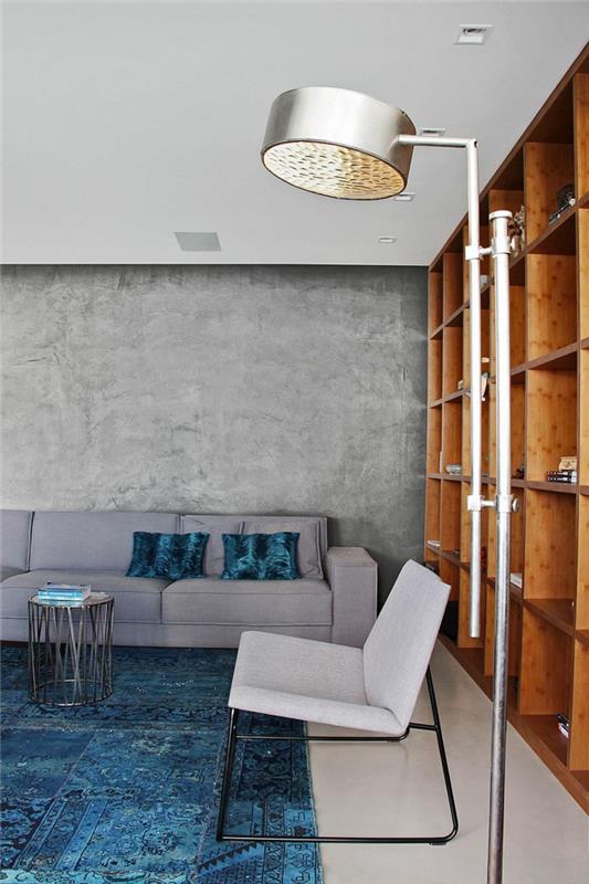 όμορφες ιδέες διαβίωσης σαλόνι με επίπλωση τσιμεντένιων τοίχων μπλε χαλί σύστημα ραφιών