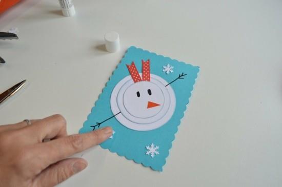 χιονάνθρωπος που κάνει μικρές χριστουγεννιάτικες κάρτες με παιδιά