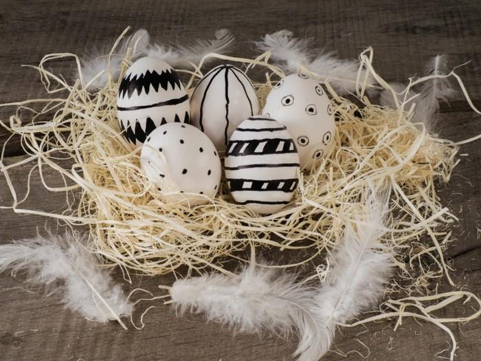 ασπρόμαυρα ζωγραφισμένα Πασχαλινά αυγά στη φωλιά με λευκά φτερά