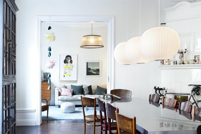 Σκανδιναβικός σχεδιασμός στην τραπεζαρία με μοντέρνο τραπέζι φαγητού και όμορφα κρεμαστά φωτιστικά