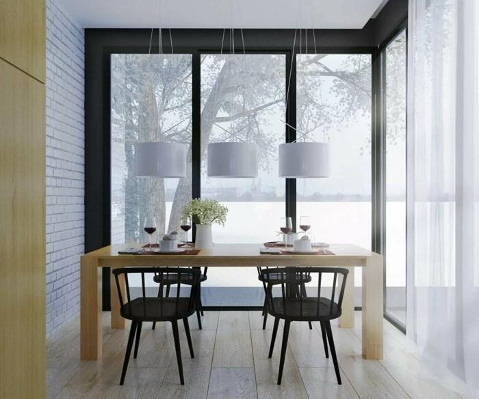 Σκανδιναβική επίπλωση της τραπεζαρίας με μαύρες καρέκλες και τοίχο από τούβλα