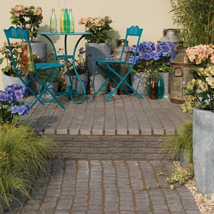 Δημιουργήστε ένα πέτρινο μονοπάτι με κήπο και πράσινα έπιπλα κήπου και πολλά λουλούδια