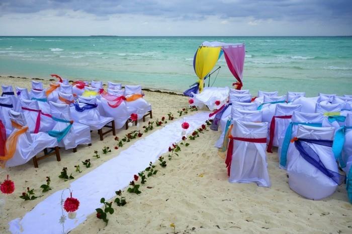 γαμήλια παραλία με πολύχρωμα υφάσματα και λουλούδια