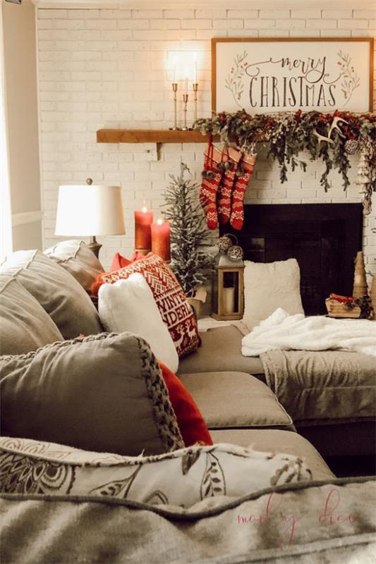 ονειρεμένες χριστουγεννιάτικες διακοσμήσεις στο σαλόνι άνετο καναπέ τζάκι έλατο πράσινα κόκκινα μποτάκια κεριά