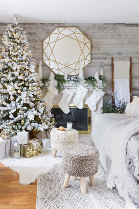 ονειρική χριστουγεννιάτικη διακόσμηση στο σαλόνι λευκή διακόσμηση λευκές μπότες Άγιου Βασίλη στρογγυλή καθρέφτη πάνω από το τζάκι