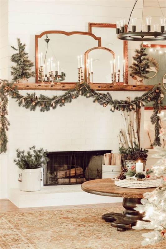ονειρεμένες χριστουγεννιάτικες διακοσμήσεις στο σαλόνι δύο μικρά έλατα δίπλα στο τζάκι έλατο πράσινη γιρλάντα ζεστή και ζεστή