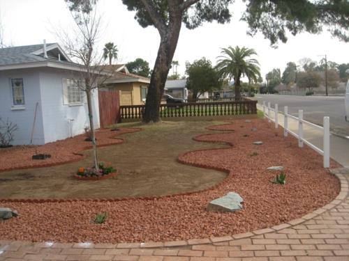 Μπροστινό σχέδιο κήπου με φυσικές πέτρες με αψιδωτά σχήματα με βότσαλα