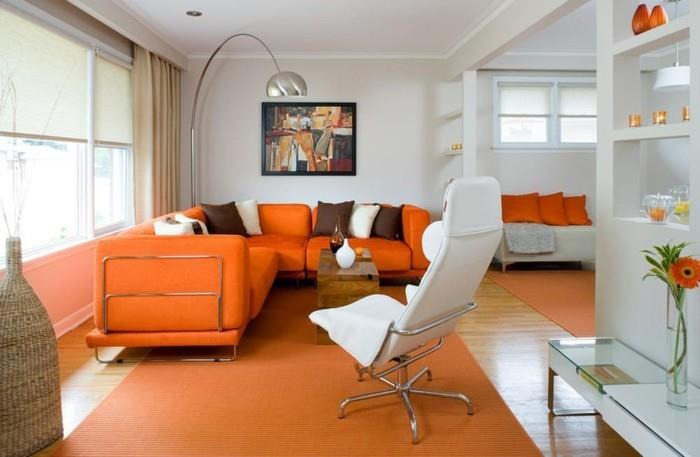 τοιχογραφίες σαλόνι πορτοκαλί καναπέδες χαλί ελαφριές κουρτίνες λευκές πολυθρόνες