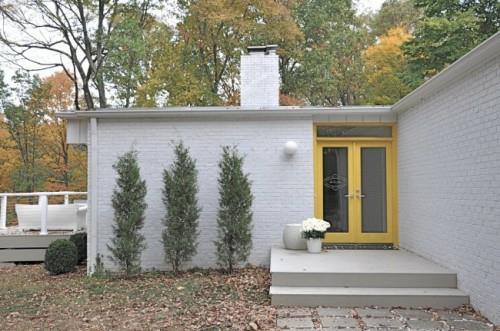 λευκό εξωτερικό τοίχο από τούβλα κίτρινα φυτά μπροστινής πόρτας