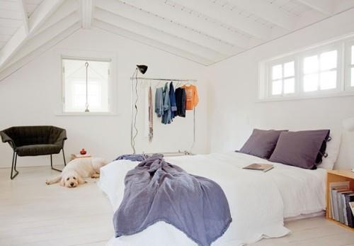 λευκό σχεδιασμένο υπνοδωμάτιο με γαλάζιες πινελιές με κεκλιμένη ράγα ρούχων οροφής