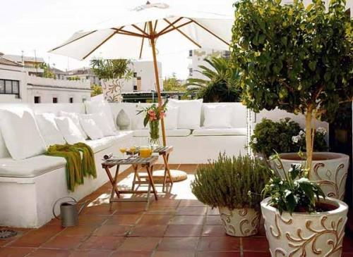 λευκός μεγάλος καναπές πέτρινα πλακάκια οροφή μπαλκόνι οροφής