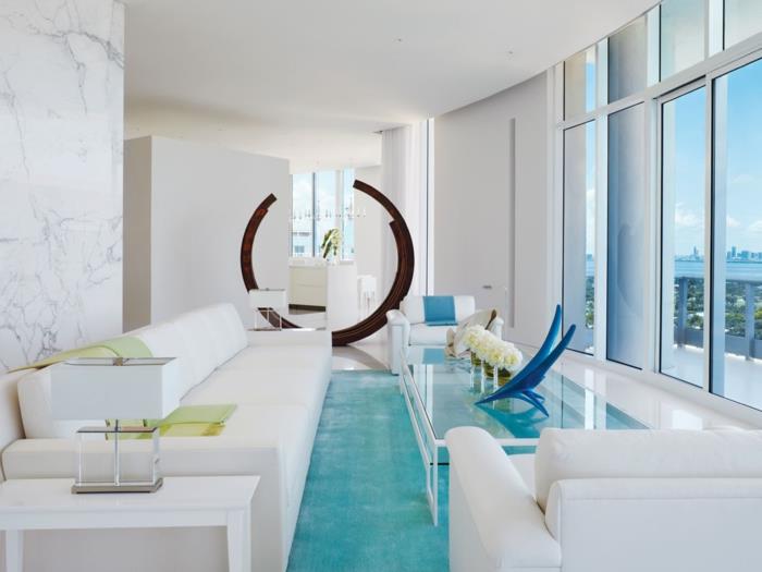 λευκό χρώμα τοίχου σαλόνι ιδέες εσωτερικού σχεδιασμού ανοιχτό μπλε χαλί γυάλινο τραπέζι λευκά έπιπλα