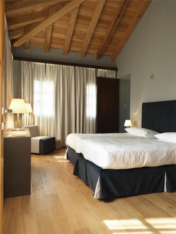 ιδέες διαβίωσης υπνοδωμάτιο λευκοί τοίχοι μαύρο κρεβάτι κεφαλάρι ξύλινα δοκάρια