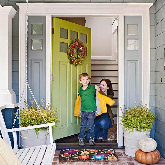 όμορφη φθινοπωρινή διακόσμηση από στοιβαγμένες κολοκύθες και πολύχρωμο στεφάνι πόρτας