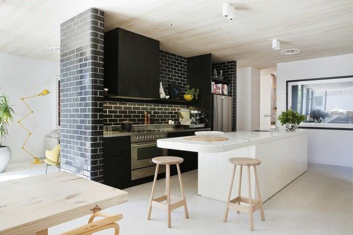 Ο τοίχος από μαύρο τούβλο στην κουζίνα έρχεται σε αντίθεση όμορφα με το λευκό νησί της κουζίνας