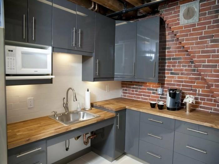 τοίχο από τούβλα και ξύλινα ντουλάπια κουζίνας σε γκρι χρώμα